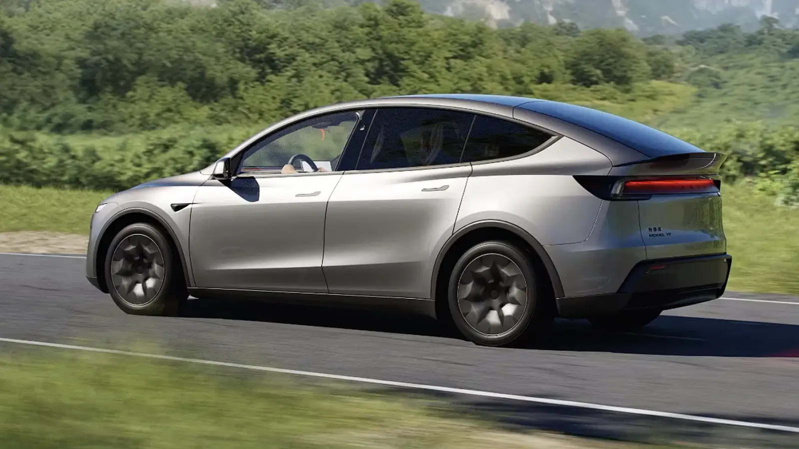 Tesla Model Y em movimento em estrada rodeada por vegetação, destacando seu design moderno e elegante.