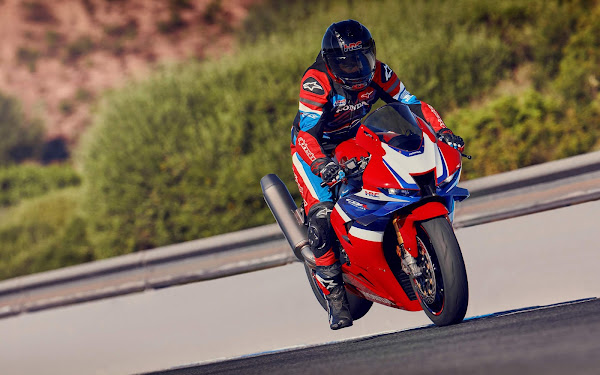 Piloto em alta velocidade com uma motocicleta esportiva Honda em pista, capturando adrenalina e performance.